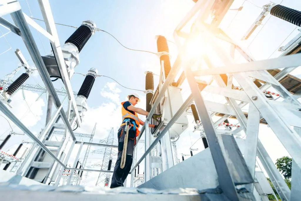 Adult electrical engineer inspect the electrical systems at the equipment control cabinet. Installation of modern electrical station