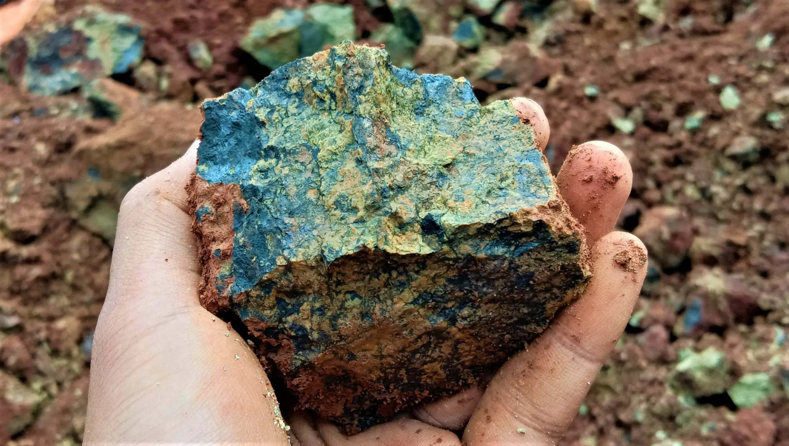 Hand holding nickel ore sample representing early-stage nickel mining engineering project work.
